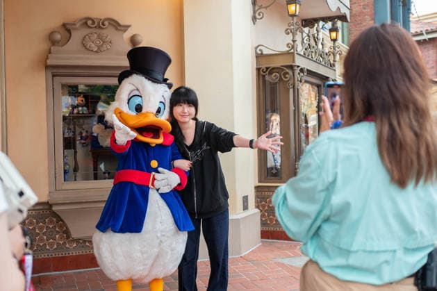 SHANGHAI, CHINA - JUNE 16: A visitor interacts with Scrooge McDuck at Shanghai Disney Resort on June 16, 2026 in Shanghai, China. The theme park is celebrating its 10th anniversary since opening, having received over 100 million visits cumulatively.  Copyright: xVCGx 111648625110