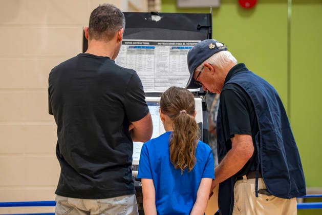 A polling operator shows a girl how the voting machines work during Washington DC s 2026 primary elections at Sherwood Recreation Center on Tuesday, June 16, 2026. The two front-runners to succeed current DC Mayor Muriel Bowser are Kenyan McDuffie, a moderate with support from many of Bowser s cabinet, and Janeese Lewis George, democratic socialist who built her campaign around organized labor.  WAP20260616321 BONNIExCASH