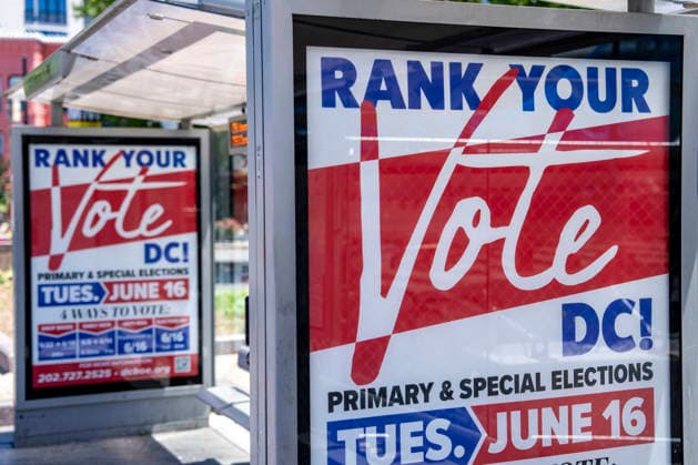 A bus stop advertisement for DC s primary elections are seen on Election Day on Tuesday, June 16, 2026. The two front-runners to succeed current DC Mayor Muriel Bowser are Kenyan McDuffie, a moderate with support from many of Bowser s cabinet, and Janeese Lewis George, democratic socialist who built her campaign around organized labor.  WAP20260616332 BONNIExCASH