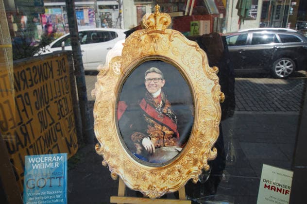 Der Buchladen Golden Shop im Bremer Steintorviertel hat in seinem Schaufenster einen goldenen Bilderrahmen aufgestellt mit einer Fotomontage, die den Kulturstaatsminister Wolfram Weimer als Fürsten darstellt. Damit reagiert die linke Buchhandlung auf die Entscheidung des konservativen Politikers, ihr nicht den Deutschen Buchhandlungspreis zu verleihen, obwohl eine Jury die Buchhandlung dafür auserwählt hatte. Als Begründung erwähnte er nicht näher erläuterte Erkenntnisse des Verfassungsschutzes. *** The Golden Shop bookstore in Bremen’s Steintor district has placed a golden picture frame in its storefront window featuring a photomontage depicting Minister of State for Culture Wolfram Weimer as a prince. This is the left-wing booksto