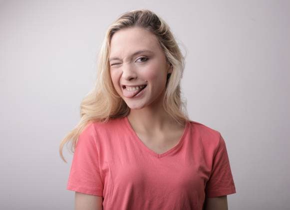 Playful blonde woman winking and sticking tongue out Budapest, Hungary R_MIPI260616-2054203-01 ,model released, Symbolfoto