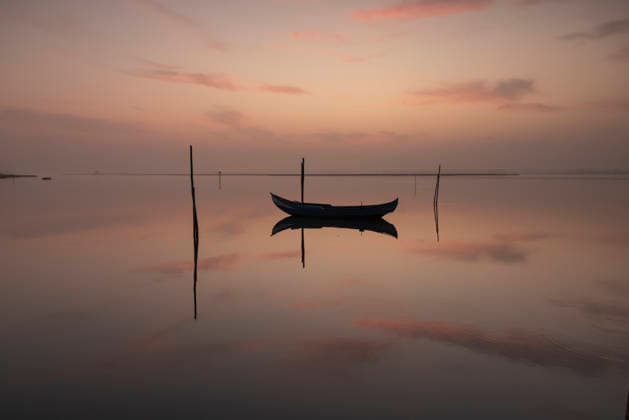 Creative Highlights World #2 Serene boat floating on reflective water at dusk Aveiro, Portugal R_NEAN2606152F-2054350-01