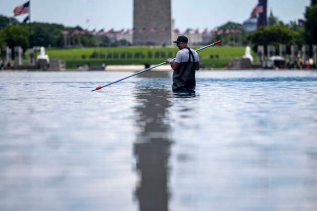 A U.S. National Park Service employee uses a vacuum pump to clean algae off the bottom of the newly repainted Lincoln Memorial Reflecting Pool on the National Mall in Washington, DC on Wednesday, June 17, 2026. The Trump Administration spent $16 million to paint the bottom of the pool American flag blue and as part of an effort to repair Washington landmarks in for preparation the country s 250th birthday this summer.  WAP20260617302 BONNIExCASH