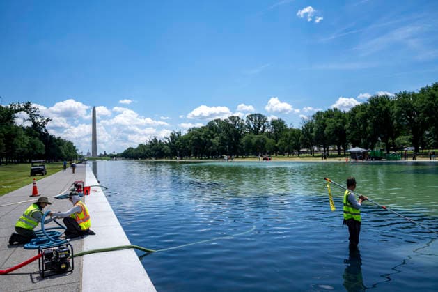 U.S. National Park Service employees use a vacuum pump to clean algae off the bottom of the newly repainted Lincoln Memorial Reflecting Pool on the National Mall in Washington, DC on Wednesday, June 17, 2026. The Trump Administration spent $16 million to paint the bottom of the pool American flag blue and as part of an effort to repair Washington landmarks in for preparation the country s 250th birthday this summer.  WAP20260617304 BONNIExCASH