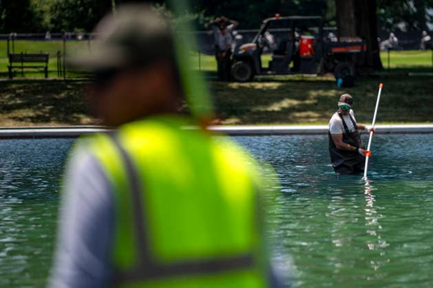 U.S. National Park Service employees use a vacuum pump to clean algae off the bottom of the newly repainted Lincoln Memorial Reflecting Pool on the National Mall in Washington, DC on Wednesday, June 17, 2026. The Trump Administration spent $16 million to paint the bottom of the pool American flag blue and as part of an effort to repair Washington landmarks in for preparation the country s 250th birthday this summer.  WAP20260617308 BONNIExCASH