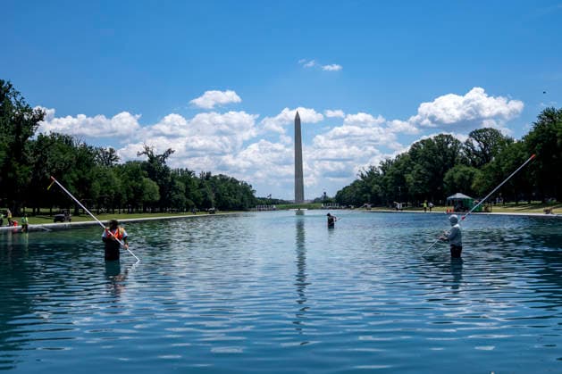 U.S. National Park Service employees use a vacuum pump to clean algae off the bottom of the newly repainted Lincoln Memorial Reflecting Pool on the National Mall in Washington, DC on Wednesday, June 17, 2026. The Trump Administration spent $16 million to paint the bottom of the pool American flag blue and as part of an effort to repair Washington landmarks in for preparation the country s 250th birthday this summer.  WAP20260617311 BONNIExCASH