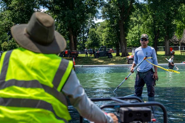 U.S. National Park Service employees use a vacuum pump to clean algae off the bottom of the newly repainted Lincoln Memorial Reflecting Pool on the National Mall in Washington, DC on Wednesday, June 17, 2026. The Trump Administration spent $16 million to paint the bottom of the pool American flag blue and as part of an effort to repair Washington landmarks in for preparation the country s 250th birthday this summer.  WAP20260617315 BONNIExCASH
