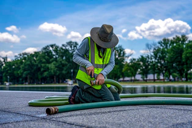 A U.S. National Park Service employee uses a vacuum pump to clean algae off the bottom of the newly repainted Lincoln Memorial Reflecting Pool on the National Mall in Washington, DC on Wednesday, June 17, 2026. The Trump Administration spent $16 million to paint the bottom of the pool American flag blue and as part of an effort to repair Washington landmarks in for preparation the country s 250th birthday this summer.  WAP20260617320 BONNIExCASH