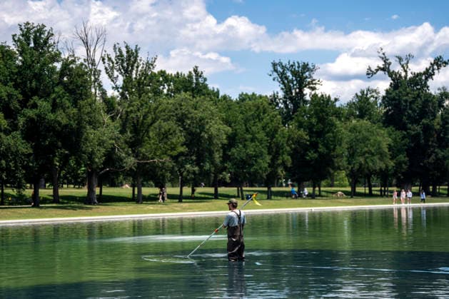 A U.S. National Park Service employee uses a vacuum pump to clean algae off the bottom of the newly repainted Lincoln Memorial Reflecting Pool on the National Mall in Washington, DC on Wednesday, June 17, 2026. The Trump Administration spent $16 million to paint the bottom of the pool American flag blue and as part of an effort to repair Washington landmarks in for preparation the country s 250th birthday this summer.  WAP20260617324 BONNIExCASH