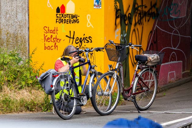 Kollision zwischen zwei Radfahrern - 80-jährige tödlich verletzt Am 17.06.2026 kam es gegen 13:50 Uhr in Kelsterbach auf dem gemeinsamen Geh- und Radweg an der Rüsselsheimer Straße im Bereich des Staudenrings zu einer Kollision zwischen zwei Radfahrenden. Eine 80-jährige Frau und ein 58-jähriger Mann stießen aus bislang ungeklärter Ursache zusammen, woraufhin die Frau stürzte und so schwere Verletzungen erlitt, dass sie noch an der Unfallstelle verstarb. Der 58-Jährige wurde leicht verletzt. Auf Antrag der Staatsanwaltschaft Darmstadt wurde ein Sachverständiger hinzugezogen; ein Polizeihubschrauber fertigte Luftaufnahmen der Unfallstelle an. Kelsterbach Hessen Deutschland *** Collision Between Two Cyclists; 80-Year-Old Fatally I