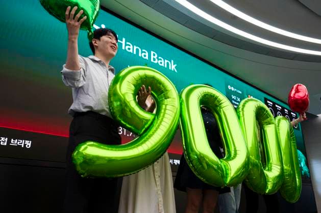 June 18, 2026, Seoul, South Korea: Workers celebrate as a display shows South KoreaÃ¢â‚¬â ¢s KOSPI index hitting historic highs on Thursday, June 18, 2026 in Seoul, South Korea. South KoreaÃ¢â‚¬â ¢s domestic KOSPI index broke the 9000-point barrier, buoyed by gains in semiconductor and AI industries driven by Samsung and SK Hynix and the announcement of a cease fire deal between the U.S. and Iran. Seoul South Korea - ZUMAh163 20260618_znp_h163_001 Copyright: xJintakxHanx