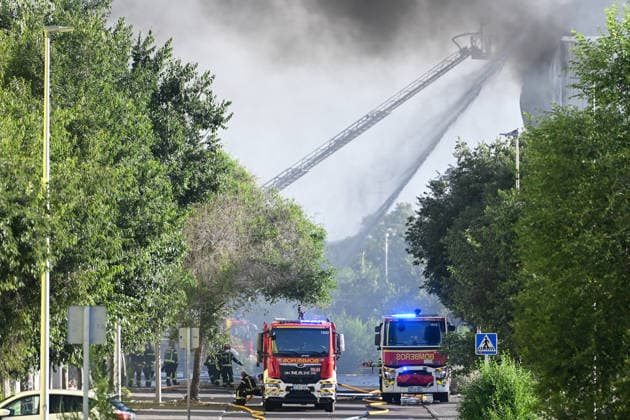 Up to 15 fire crews are working to extinguish a fire in a warehouse in Villaverde, Madrid. Two fire trucks are working to extinguish the fire in a warehouse in Villaverde on June 18, 2026, in Madrid, Spain. Up to 15 fire crews from the Madrid City Council have been working since early this morning to put out a fire at a storage warehouse located on San Mamés Street, in the Villaverde district of Madrid. The fire, which has broken out on three of the building’s four facades, has forced the evacuation of a gas station and has produced a large column of smoke visible even from other parts of Madrid and the surrounding area. June 18, 2026, Madrid, Spain,detected_source_language  Copyright: xGustavoxValientex 7605276