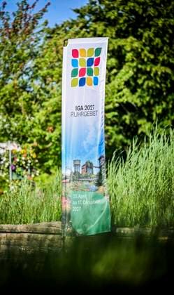 Pressekonferenz im Grugapark Essen, Picknick XXL: Die Internationale Gartenausstellung (IGA) 2027 Ruhrgebiet will am 20. Juni 2027 bis zu 100.000 Menschen zum IGA-Picknick zusammenbringen. An mehr als 50 Standorten im gesamten Ruhrgebiet sollen sie zusammenkommen und einen möglichen Weltrekord aufstellen. Die Veranstaltung wird gemeinsam mit zahlreichen Kommunen und Partnern aus der Region umgesetzt und soll die Vielfalt, den Zusammenhalt und die grünen Qualitäten der Region sichtbar machen. Die Schirmherrschaft übernimmt NRW-Ministerpräsident Hendrik Wüst. ** NUR FÜR REDAKTIONELLE ZWECKE ** EDITORIAL USE ONLY **<p>IGA- Banner im Grugapark am Donnerstag, dem 18. Juni 2026. IGA 2027 plant Picknick-Weltrekord für das Ruhrgebiet, Copyright: KerstinxKokoska doc86cadfguuo711wrzn823 ,EDITORIAL USE ONLY