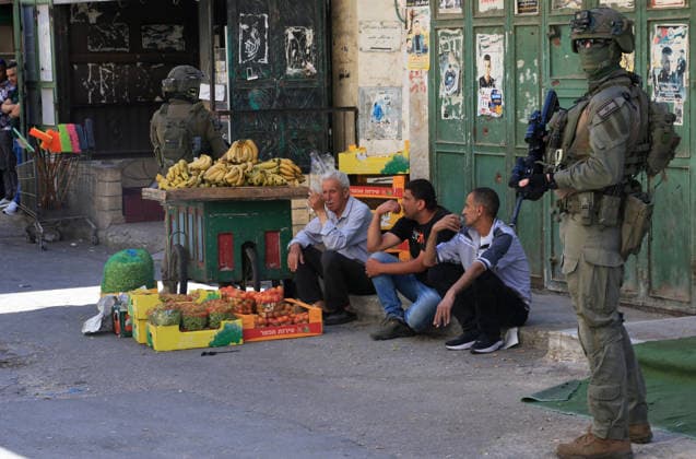 June 18, 2026, Nablus, West Bank, Palestine: An Israeli soldier stands in the middle of the market as Palestinian vendors display fruits and vegetables during a raid on Balata refugee camp east of Nablus in the West Bank. Israeli forces raided the central market during a security operation. Palestinian sources said that the army arrested seven Palestinians from various neighborhoods in Nablus and its surrounding refugee camps. Nablus Palestine - ZUMAs197 20260618_aaa_s197_019 Copyright: xNasserxishatyehx