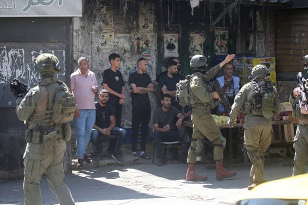 June 18, 2026, Nablus, West Bank, Palestine: Israeli soldiers stop young Palestinians at the entrance to the market during a raid on Balata refugee camp east of Nablus in the West Bank. Israeli forces raided the central market during a security operation. Palestinian sources said that the army arrested seven Palestinians from various neighborhoods in Nablus and its surrounding refugee camps. Nablus Palestine - ZUMAs197 20260618_aaa_s197_008 Copyright: xNasserxishatyehx