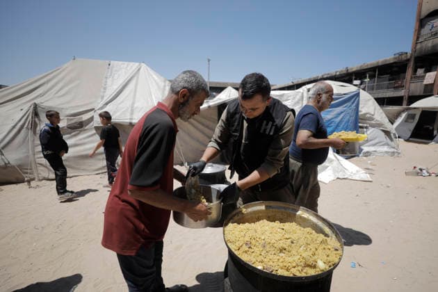 Jabalia Gaza Strip Displacement Crisis A volunteer serves food aid to displaced Palestinians at the Al-Faluja School shelter in Jabalia, in the northern Gaza Strip, on June 18, 2026. Thousands of displaced families in northern Gaza rely on humanitarian assistance as shortages of food, water and basic supplies persist amid the continuing conflict and humanitarian crisis. Gaza Gaza Strip Palestinian Territories Copyright: xAhmedxAlxArinix