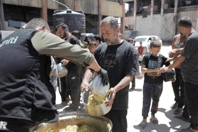 Jabalia Gaza Strip Displacement Crisis A volunteer serves food aid to displaced Palestinians at the Al-Faluja School shelter in Jabalia, in the northern Gaza Strip, on June 18, 2026. Thousands of displaced families in northern Gaza rely on humanitarian assistance as shortages of food, water and basic supplies persist amid the continuing conflict and humanitarian crisis. Gaza Gaza Strip Palestinian Territories Copyright: xAhmedxAlxArinix