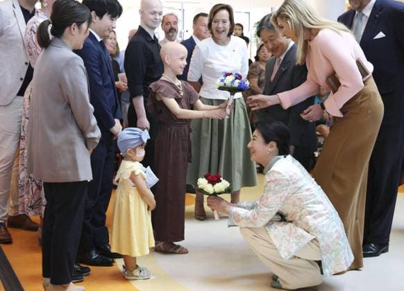 Japan s imperial couple visit children s cancer hospital in Utrecht Japan s Empress Masako (front, R) receives flowers from a child during a visit to a hospital for child cancer patients in Utrecht, the Netherlands, on June 19, 2026. (Pool photo)  A14AA0005619470P