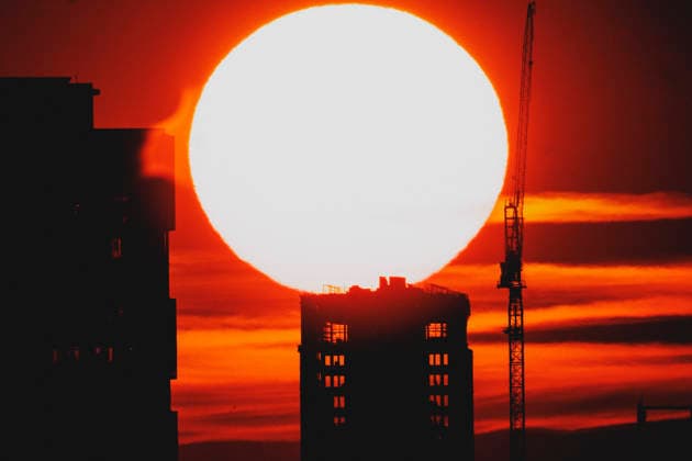 Die untergehende Sonne zeichnet sich ab hinter einem Neubau mit Kran in Berlin, 19.06.2026. In ganz Deutschland herrscht aktuell eine Hitzewelle. Berlin Deutschland *** The setting sun is visible behind a new building with a crane in Berlin, June 19, 2026. A heat wave is currently affecting all of Germany. Berlin, Germany,detected_source_language Copyright: xFlorianxGaertnerx