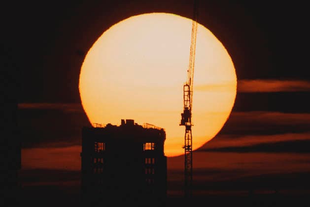 Die untergehende Sonne zeichnet sich ab hinter einem Neubau mit Kran in Berlin, 19.06.2026. In ganz Deutschland herrscht aktuell eine Hitzewelle. Berlin Deutschland *** The setting sun is visible behind a new building with a crane in Berlin, June 19, 2026. A heat wave is currently affecting all of Germany. Berlin, Germany,detected_source_language Copyright: xFlorianxGaertnerx