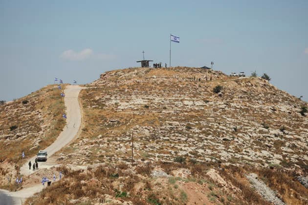 Protest Against Settlers in Dura Israeli flags line a dirt path leading to a hilltop outpost in Jabal Tarousa near Dura, south of Hebron, in the occupied West Bank, on June 19, 2026. Palestinians held Friday prayers nearby to protest the establishment of the newly built Israeli settlement outpost and the seizure of land. Israeli forces later fired tear gas to suppress the gathering, allegedly causing several people, including journalists, to suffer from inhalation. Dura West Bank Palestinian Territories Copyright: xMosabxShawerx