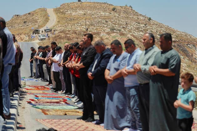 Protest Against Settlers in Dura Palestinian men perform Friday prayers on a road near a hilltop Israeli outpost in Jabal Tarousa near Dura, south of Hebron, in the occupied West Bank, on June 19, 2026. Palestinians held the prayers to protest the establishment of the newly built Israeli settlement outpost and the seizure of land. Israeli forces later fired tear gas to suppress the gathering, allegedly causing several people, including journalists, to suffer from inhalation. Dura West Bank Palestinian Territories Copyright: xMosabxShawerx