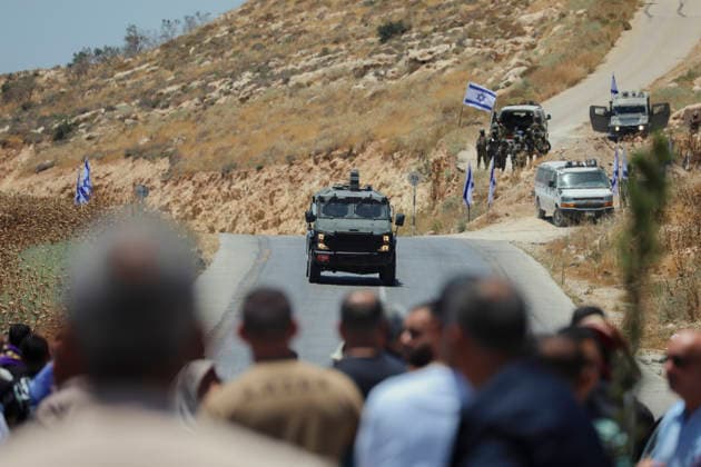 Protest Against Settlers in Dura An Israeli military vehicle drives toward a crowd of Palestinian men gathered on a road in Jabal Tarousa near Dura, south of Hebron, in the occupied West Bank, on June 19, 2026. Palestinians held Friday prayers to protest the establishment of a newly built Israeli settlement outpost and the seizure of land. Israeli forces later fired tear gas to suppress the gathering, allegedly causing several people, including journalists, to suffer from inhalation. Dura West Bank Palestinian Territories Copyright: xMosabxShawerx