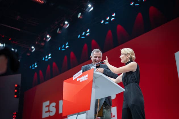 Die Parteivorsitzende Ines Schwerdtner verabschiedet ihren bisherigen Co-Vorsitzenden Jan van Aken und übergibt eine Tax the Rich-Gärtnerschütze sowie ein T-Shirt mit dem Aufdruck Jan van Sprachen;Bundesparteitag Die Linke in Potsdam - Potsdamer Parteitag 2026, Potsdam Brandenburg Deutschland Metropolis-Halle *** Party Chair Ines Schwerdtner bids farewell to her former co-chair, Jan van Aken, and presents him with a Tax the Rich garden t-shirt and a T-shirt emblazoned with Jan van Sprachen. The Left Party Federal Convention in Potsdam; 2026 Potsdam Party Convention; Potsdam, Brandenburg, Germany; Metropolis Hall,detected_source_language