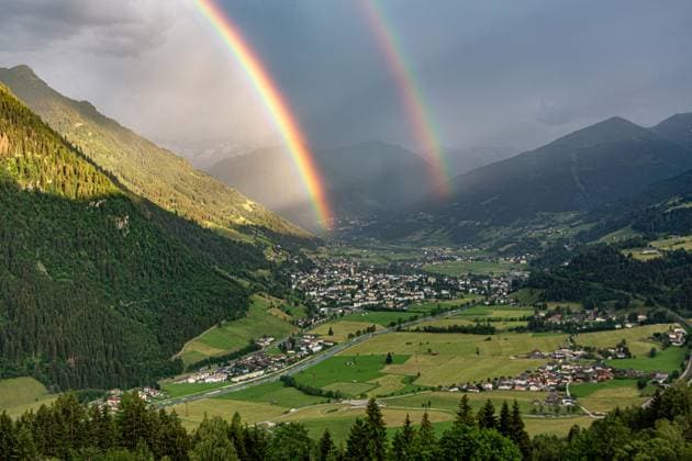Luftaufnahme des österreichischen Kurorts Bad Hofgastein im Gasteinertal, über dem sich ein markanter Doppelregenbogen vor einer alpinen Bergkulisse erstreckt. Regenbogen im Gasteinertal *** Aerial view of the Austrian resort town of Bad Hofgastein in the Gastein Valley, with a striking double rainbow arching over it against an alpine mountain backdrop Rainbow in the Gastein Valley,detected_source_language