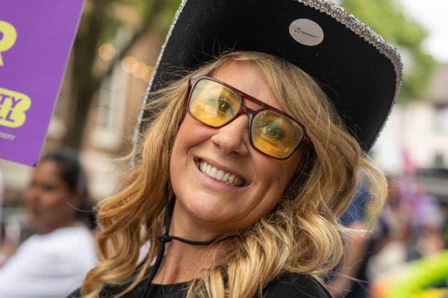 June 20, 2026, Essex, United Kingdom: A woman wearing a wide-brimmed black hat and tinted glasses smiles during the Essex Pride. Essex Pride is a celebration of lesbian, gay, bisexual and transgender life in Essex and beyond, led by Cheryl Hole, also known as Cheryl the Queen. Essex United Kingdom - ZUMAs197 20260620_aaa_s197_100 Copyright: xIanxDavidsonx