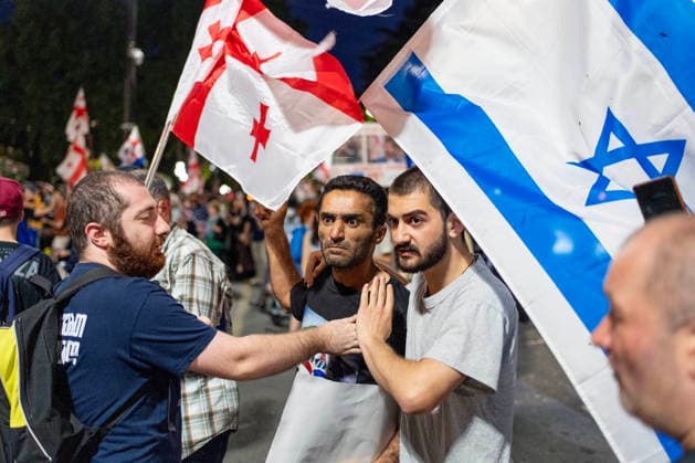 June 20, 2026, Tbilisi, Georgia: A free-Iran supporter holding an Israeli flag clash with a pro-Islamic regime of Iran supporter (not seen) as he and others participate on the 570th day of anti-government rallies in Tbilisi. Tbilisi Georgia  - ZUMAz174 20260620_zip_z174_008 Copyright: xMoexZoyarix