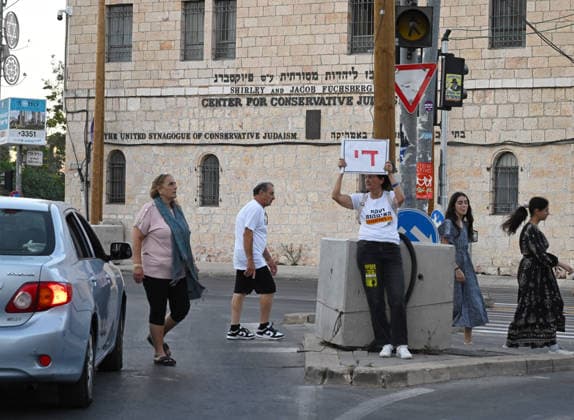 A woman holds a handmade sign reading in Hebrew Enough at a protest calling for Israeli Prime Minister Benjamin Netanyahu to stop the wars near his residence in Jerusalem on Saturday, June 20, 2026. U.S. President Donald Trump has called on Prime Minister Netanyahu to stop the military strikes in Lebanon.  JER2026062011 DEBBIExHILL