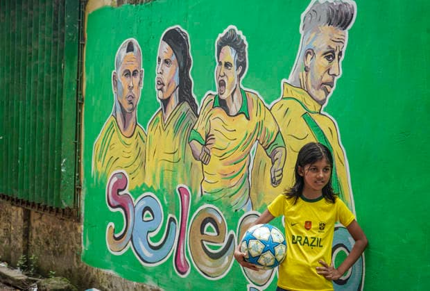 June 21, 2026, Chittagong, Chittagong, Bangladesh: Children gather around FIFA World Cup 2026-themed murals, posing with footballs, reenacting iconic celebrations and mimicking their favourite players. Painted on the walls of a residential neighbourhood, the murals have become a focal point for local youngsters, reflecting how football fever reaches beyond the pitch and brings communities together through shared passion and play. Chittagong Bangladesh - ZUMAs356 20260621_zip_s356_005 Copyright: xMohammedxSumanx