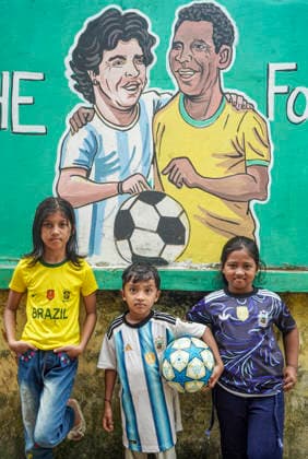 June 21, 2026, Chittagong, Chittagong, Bangladesh: Children gather around FIFA World Cup 2026-themed murals, posing with footballs, reenacting iconic celebrations and mimicking their favourite players. Painted on the walls of a residential neighbourhood, the murals have become a focal point for local youngsters, reflecting how football fever reaches beyond the pitch and brings communities together through shared passion and play. Chittagong Bangladesh - ZUMAs356 20260621_zip_s356_016 Copyright: xMohammedxSumanx