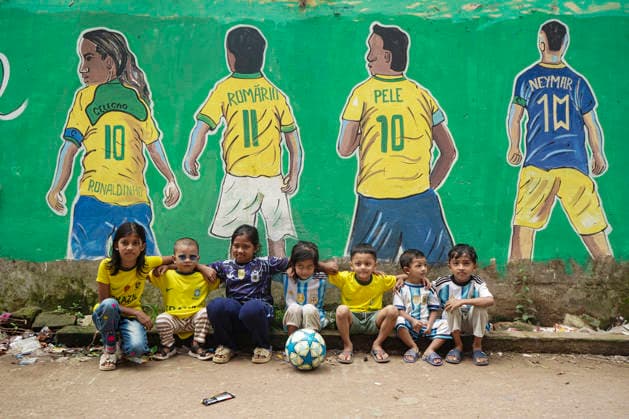 June 21, 2026, Chittagong, Chittagong, Bangladesh: Children gather around FIFA World Cup 2026-themed murals, posing with footballs, reenacting iconic celebrations and mimicking their favourite players. Painted on the walls of a residential neighbourhood, the murals have become a focal point for local youngsters, reflecting how football fever reaches beyond the pitch and brings communities together through shared passion and play. Chittagong Bangladesh - ZUMAs356 20260621_zip_s356_017 Copyright: xMohammedxSumanx