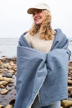 Young woman smiling wrapped in a blanket on a beach Narragansett, Rhode Island, United States CR_CABR260619-2057186-01 ,model released, Symbolfoto