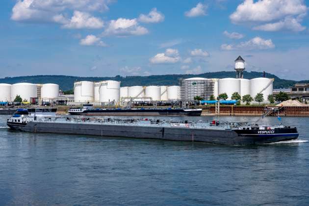 Frachtschiff auf dem Rhein, Höhe Bendorf, im Kreis Mayen-Koblenz, rechtsrheinisch, Tanklager der enport GmbH, 22 Großtanks, hauptschädlich für Kraftstoffe, Rheinland-Pfalz, Deutschland, Tanklager *** Cargo ship on the Rhine, near Bendorf, in the Mayen-Koblenz district, on the right bank of the Rhine, enport GmbH tank farm, 22 large tanks, primarily used for fuels, Rhineland-Palatinate, Germany, tank farm,detected_source_language