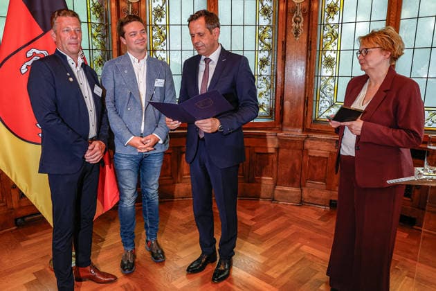Verleihung der Niedersächsischen Sportmedaille: Ministerpräsident Lies und Sportministerin Behrens ehren niedersächsische Athletinnen und Athleten (v.l.n.r.) Lars Kruckenberg, Resortleiter Sport, Turn- und Sportverein Algesdorf e.V., Rodenberg; Felix Kruckenberg, Resortleiter Kommunikation, Turn- und Sportverein Algesdorf e.V., Rodenberg, Olaf Lies (SPD), Ministerpräsident Niedersachsen liest den Text in der Urkunde der Auszeichnung mit der Niedersächsischen Sportmedaille in der Kategorie Beispielhafte Vereinsarbeit vor, Daniela Behrens (SPD) - Ministerin für Inneres, Sport und Digitalisierung hält die Sportmedaille in den Händen 30175 Hannover, Lüerstraße 5 Gästehaus der Niedersächsische Niedersachsen, Region Hannover Germany
