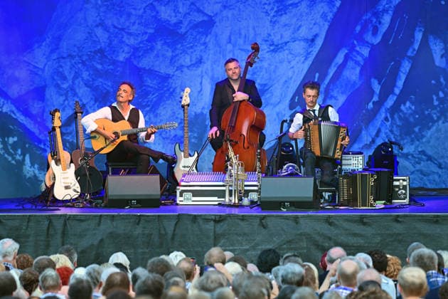 Open-air concert by the Herbert Pixner Project on the Toscana Peninsula in Gmunden, photographed on June 22, 2026. The photo shows, from left to right, guitarist Manuel Rand, bassist Werner Unterlerchner, bandleader and accordionist Herbert Pixner in front of the audience at the 2022 open-air concert by the Herbert Pixner Project on the Toscana Peninsula in Gmunden, on June 22, 2026,detected_so