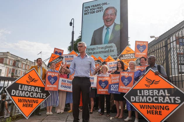 June 23, 2026, London, London, UK: London, UK. Dr Al Pinkerton, Liberal Democrat MP for Surrey Heath, addresses party MPs and activists in front of a digital billboard in Fulham, London, during the launch of the party s new national campaign targeting Reform UK leader Nigel Farage and highlighting a Â£5 million gift he received, as the party marks the 10th anniversary of the Brexit referendum with the launch of its nationwide billboard campaign. London UK  - ZUMAl94_ 20260623_zaf_l94_016 Copyright: xDinendraxHariax