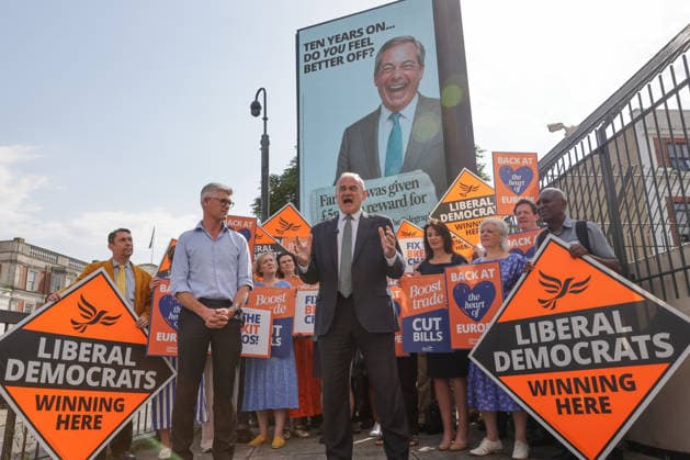 June 23, 2026, London, London, UK: London, UK. Liberal Democrat leader Ed Davey addresses party MPs and activists in front of a digital billboard in Fulham, London, during the launch of a new national campaign targeting Reform UK leader Nigel Farage and highlighting a Â£5 million gift he received, as the party marks the 10th anniversary of the Brexit referendum with the launch of its nationwide billboard campaign. London UK  - ZUMAl94_ 20260623_zaf_l94_022 Copyright: xDinendraxHariax