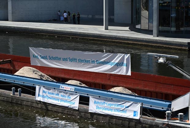 Cargo ship blocks Spree River during rally in Berlin BERLIN, GERMANY - JUNE 24: Construction aggregates are seen aboard a cargo ship blocking the Spree River in front of the Reichstag building during a demonstration organized by MIRO, the German minerals and aggregates industry association, in Berlin, Germany, on June 24, 2026. The vessel, loaded with mineral raw materials, was used as part of a protest calling for stronger legal protection of mineral deposits and greater consideration of domestic resource extraction in spatial planning legislation. Volodymyr Sindieiev Anadolu Berlin Germany. Editorial use only. Please get in touch for any other usage.  Copyright: x2026xAnadoluxVolodymyrxSindieievx