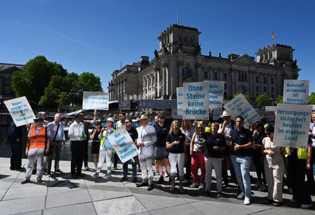 Cargo ship blocks Spree River during rally in Berlin BERLIN, GERMANY - JUNE 24: Participants gather on the banks of the Spree River as a cargo ship blocks the waterway in front of the Reichstag building during a rally organized by MIRO, the German minerals and aggregates industry association, in Berlin, Germany, on June 24, 2026. An 80-meter cargo ship loaded with construction aggregates blocked traffic on the Spree River while demonstrators called for stronger legal protection of mineral deposits and greater consideration of domestic mineral resource extraction and processing in spatial planning legislation. Volodymyr Sindieiev Anadolu Berlin Germany. Editorial use only. Please get in touch for any other usage.  Copyright: x2026xAnadoluxVolodymyrxSindieievx