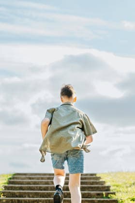 Teenage boy climbing steps outdoors with determination Corby, England, United Kingdom R_JNDO260623-2060647-01 ,model released, Symbolfoto