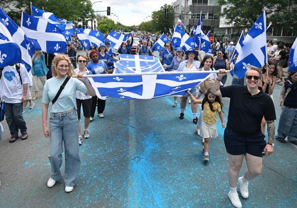 June 24, 2026, Montreal, Pq, Canada: Participants carry a Quebec flag along a street during the Saint-Jean-Baptiste Day parade in Montreal, on Wednesday, June 24, 2026. Montreal Canada  - ZUMAc35_ 20260624_zaf_c35_081 Copyright: xGrahamxHughesx