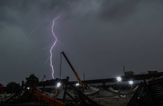 Lightning flashes as dark clouds loom over the site where the shed of an under-construction warehouse collapsed in Taratala Kolkata, Jun 25 (ANI): Lightning flashes as dark clouds loom over the site where the shed of an under-construction warehouse collapsed in Taratala, in Kolkata on Thursday. Kolkata West Bengal India Copyright: xANIx ANI_20260625105