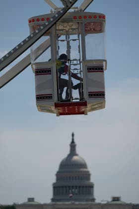 June 25, 2026, Washington, Dc, United States: People ride in the gondola of a giant ferris wheel operating with the U.S Capitol Building dome behind during the Great American State Fair on the National Mall, June 25, 2026 in Washington, D.C. The event, organized to celebrating the nation s 250th anniversary, features a carnival midway, and exhibits has been heavily politicized. Washington United States - ZUMAp138 20260625_zaa_p138_027 Copyright: xBrienxAho Usdax