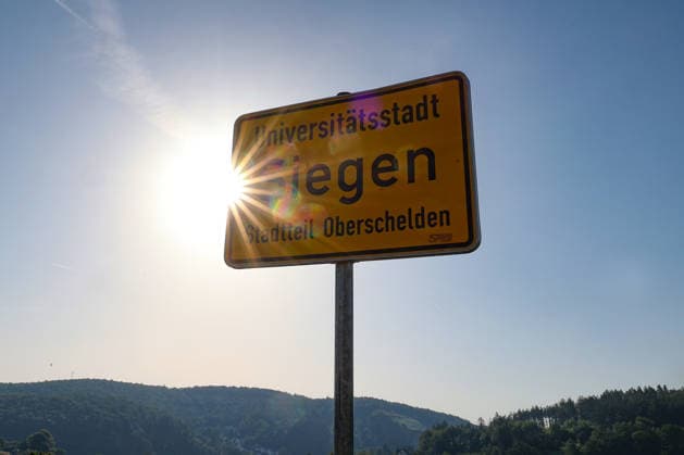Sommer im Siegerland. Es ist sehr heiss (heiß) und die Temperaturen sollen weiter ansteigen. Der Himmel ist blau und die Sonne strahlt vom wolkenlosen Himmel. Im Vordergrund ein Ortseingangsschild der Universitaetsstadt (Universitätsstadt) Siegen Stadtteil Oberschelden. Sommer am 26.06.2026 in Siegen Deutschland. *** Summer in the Siegerland. It’s very hot, and temperatures are expected to rise further. The sky is blue, and the sun is shining from a cloudless sky. In the foreground is a town sign marking the entrance to the university town of Siegen, in the Oberschelden district. Summer on June 26, 2026, in Siegen, Germany