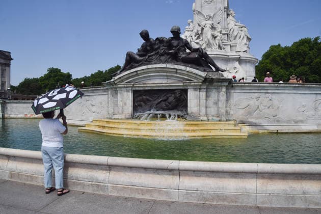 June 26, 2026, London, England, United Kingdom: A tourist takes photos of a fountain at the base of the Victoria Memorial outside Buckingham Palace as the Met Office issues an amber warning for extreme heat. London United Kingdom - ZUMAv130 20260626_zip_v130_015 Copyright: xVukxValcicx