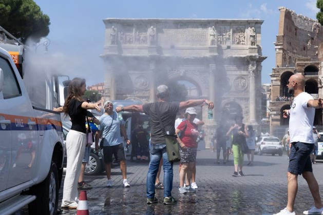 IPA86089435 - Tourists cool off with the Civil Protection Agency s mobile misting systems in front of the Colosseum amid the scorching heat  Copyright: xMatteoxNardonex xx 86089435